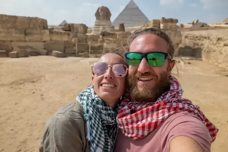 Una pareja tomándose una foto con las pirámides.
